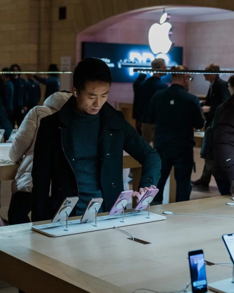 A man looking at phones inside an Apple Store