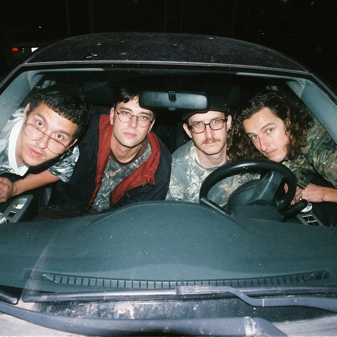 Band poses from inside a car at night time. 