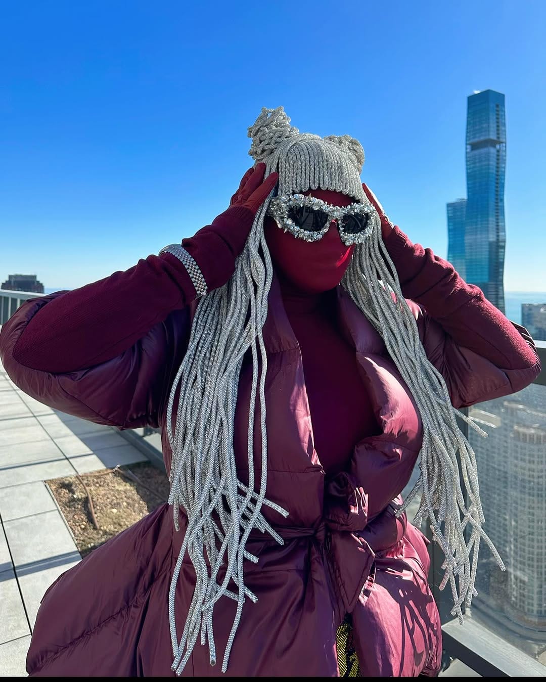 Artist poses with a head to toe outfit, concealing their face. 