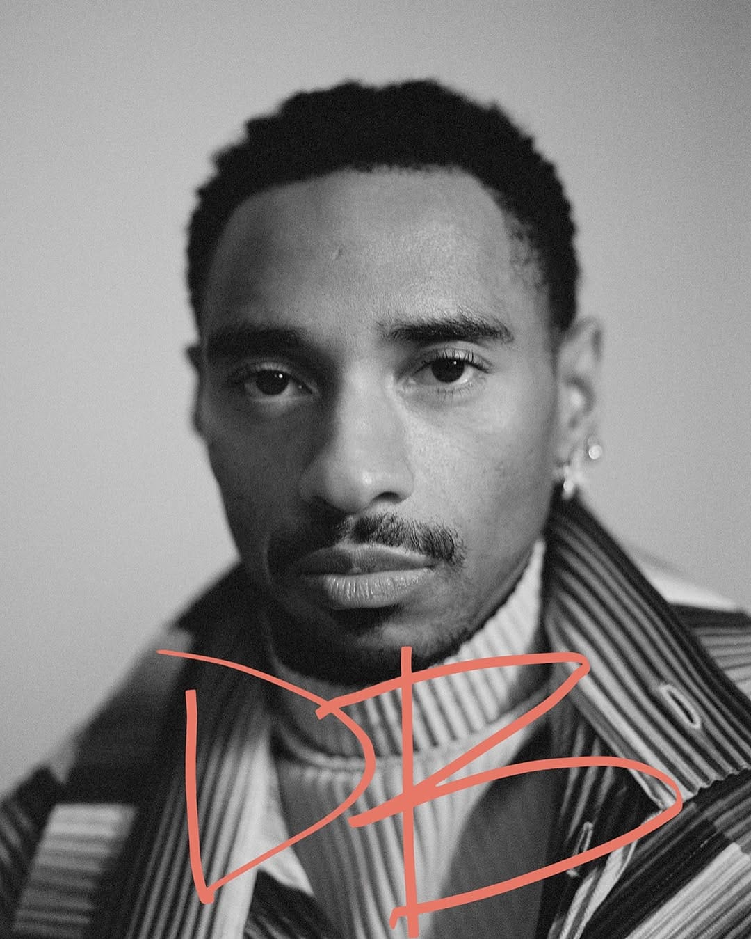 Artist poses in front of a blank background.
