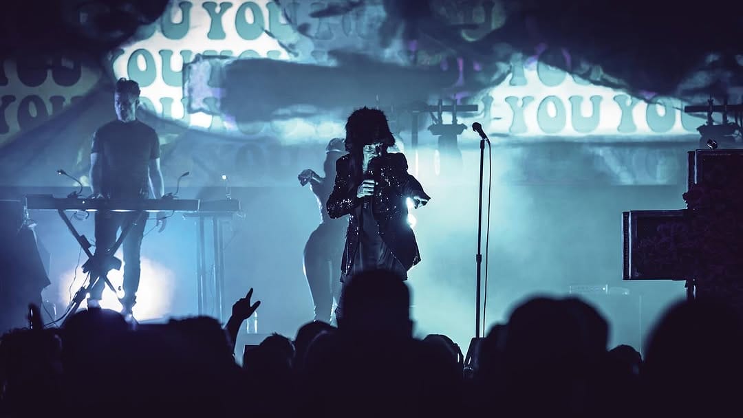 Band performing in a venue in front of a crowd. 