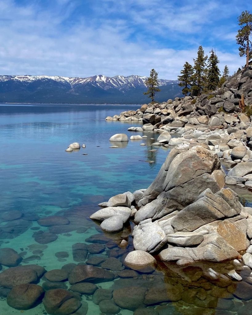 Lake Tahoe clear water with mountains and rocky shoreline scenic view