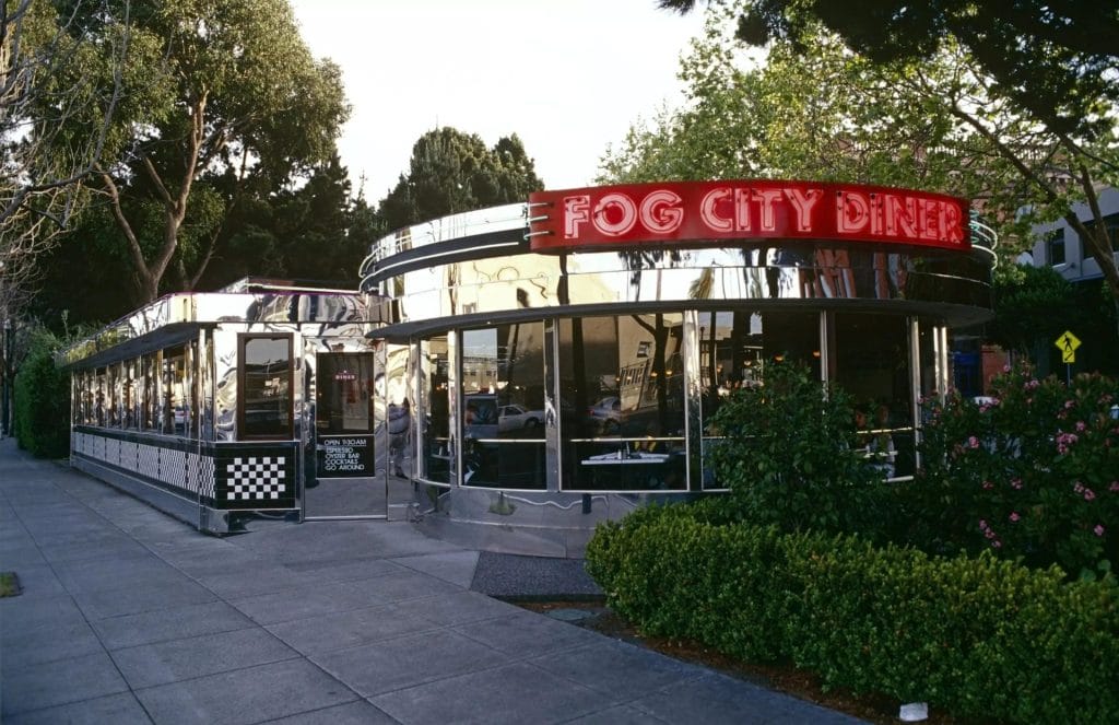 San Francisco Restaurants exterior showing Fog City Diner with retro signage, large windows, greenery, and a sidewalk entrance.