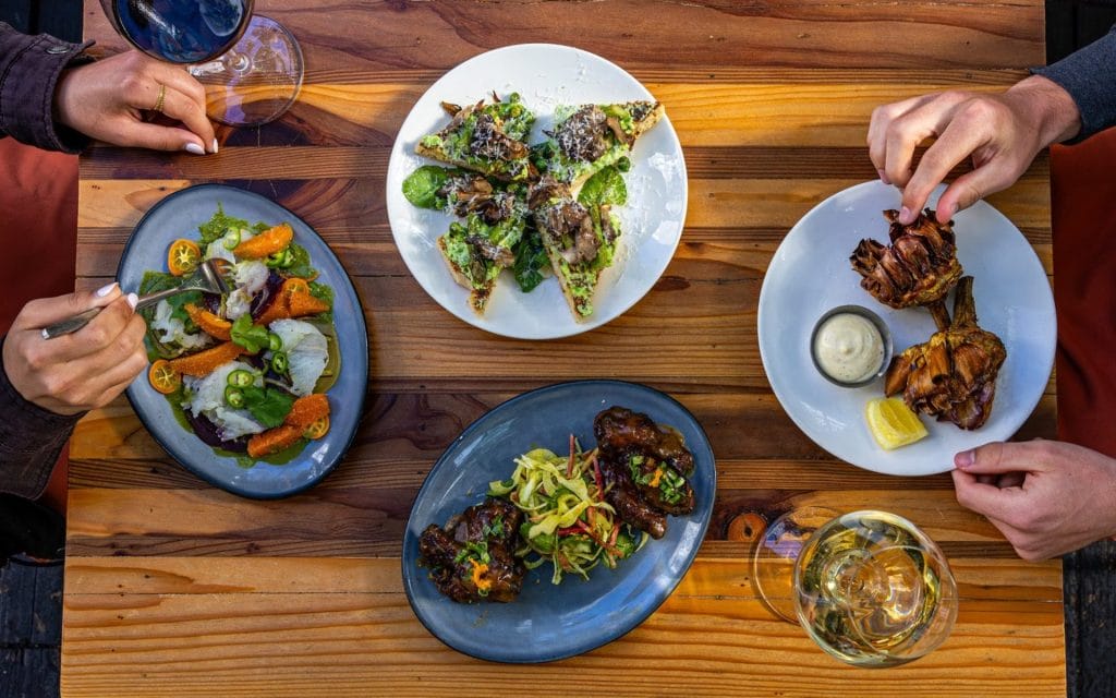 Father’s Day brunch at Fable in San Francisco, featuring shareable plates, artichokes, salad, toast, and drinks on an outdoor table.