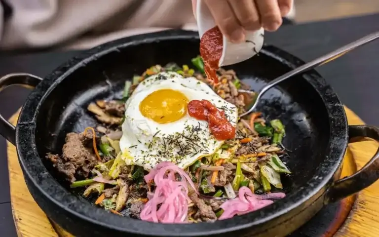 Korean bibimbap, rice bowl topped with vegetables, meat and fried egg