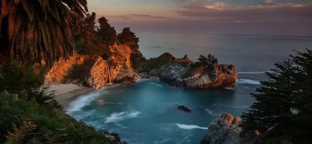 Hidden gems along Highway 1, scenic landscape of McWay Falls in Big Sur, California at sunset