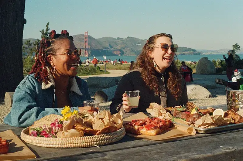 people enjoying Italian-inspired pizza and focaccia at il Parco in San Francisco Presidio Tunnel Tops Park with the views of the Golden Gate Bridge.