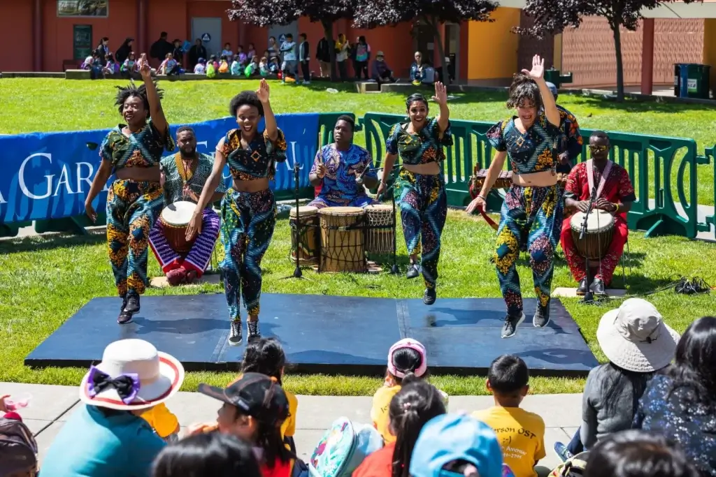 Dancers and drummers performing outdoors for a children’s audience at Yerba Buena Gardens Festival in San Francisco.