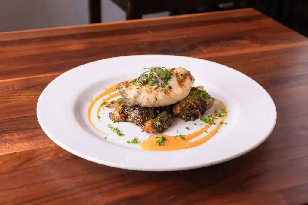 Ailment sea bass dish garnished with parsley