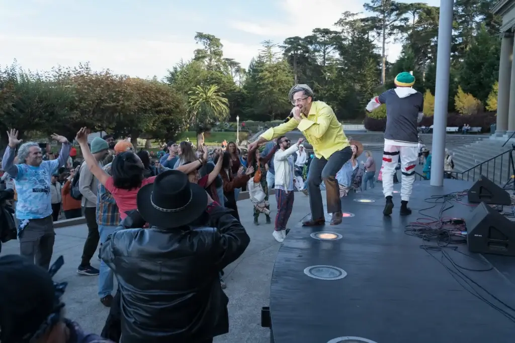 Performer singing onstage while the crowd dances at the Golden Gate Bandshell in San Francisco.