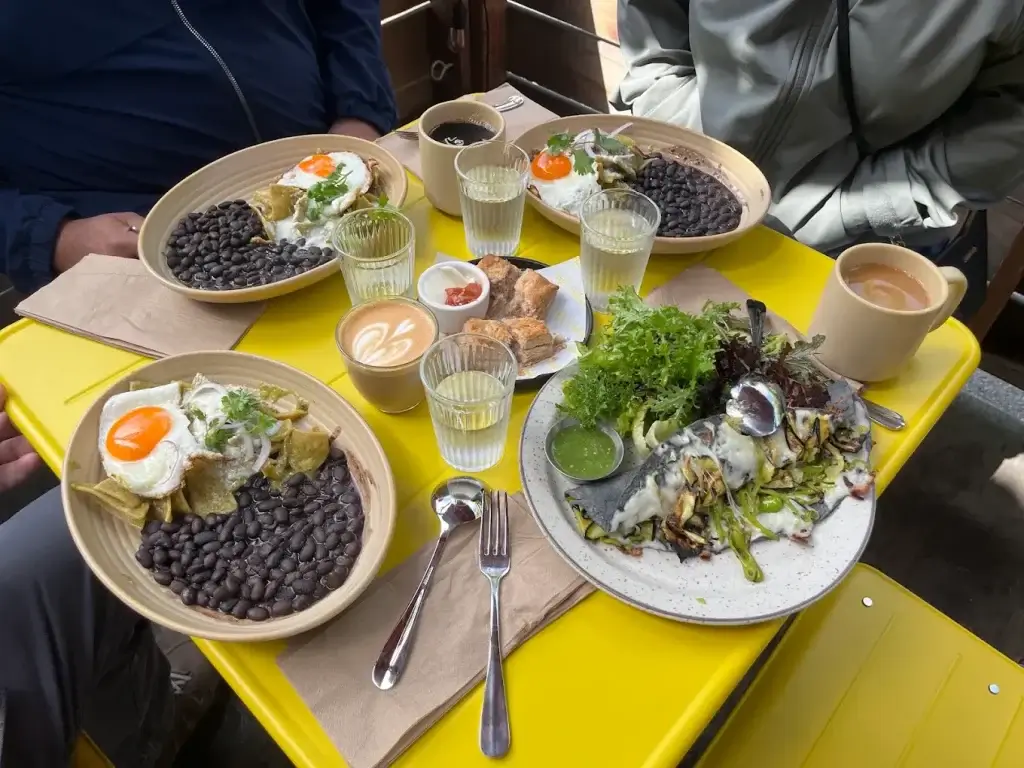 brunch with black beans, fried eggs and salad along with coffee and water