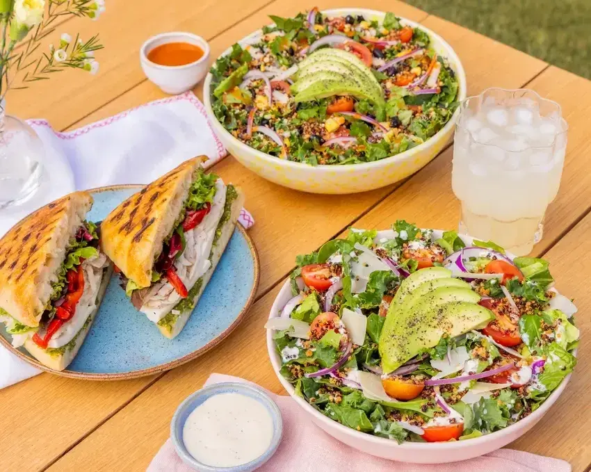 large bowl of salad with avocado, smaller side dishes and sandwiches. Mendocino Farms restaurants near Oracle Park San Francisco