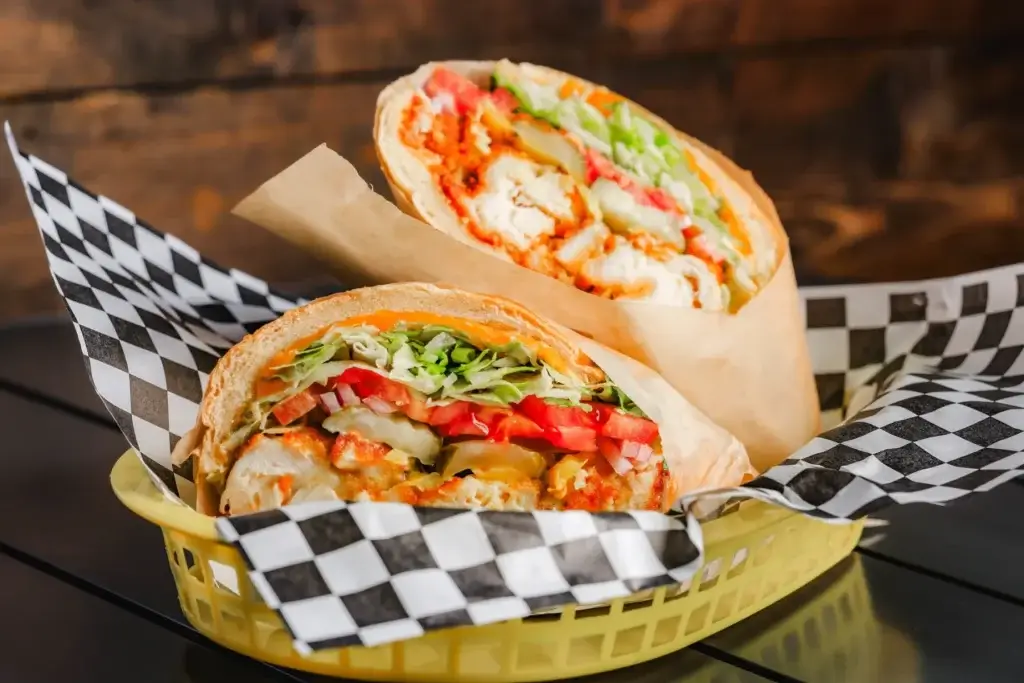 Fried chicken sandwich from the Hidden Spot served in a yellow basket with black and white checkered paper.