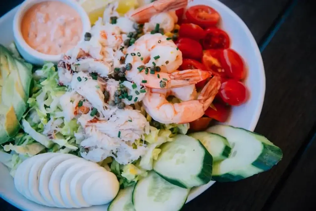 seafood salad featuring shrimp, crab tomatoes, sliced boiled egg, and cucumber. restaurant near Oracle Park MoMo's